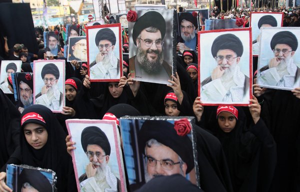 The children of Lebanese Hizbullah members hold portraits of Hizbullah chief Hassan Nasrallah and Iranian leader Ali Khamenei during a procession in the southern Lebanese city of Nabatieh on October 4, 2017. [Mahmoud Zayyat/AFP]