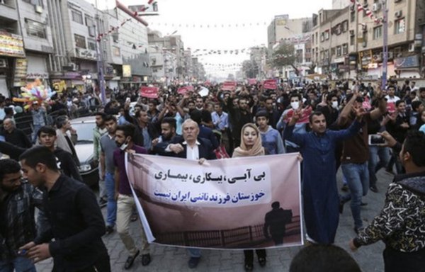 Protesters in Iran's Khuzestan province in the summer of 2021 carry a banner that reads, 'Drought, Unemployment, Illness...Khuzestan is not Iran's stepchild.' [Mehr News]