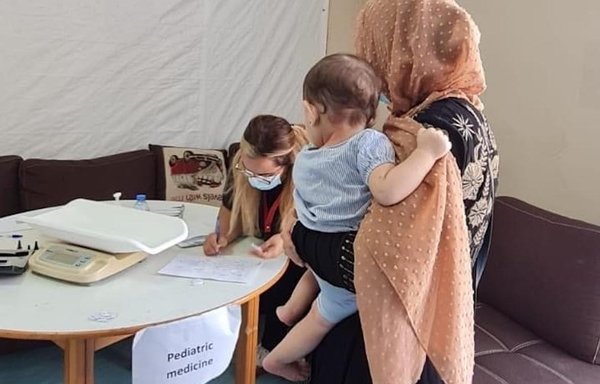 در این عکس بدون تاریخ، یک مادر و فرزند به کلینیکی در لبنان مراجعه کرده‌اند. ایالات متحده آمریکا برای پناهجویان سوری در لبنان کمک‌هزینه خدمات بهداشتی تأمین کرده است. [سفارت ایالات متحده در لبنان]