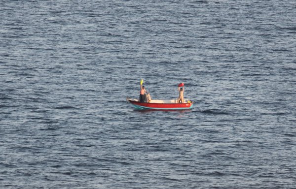 Two Iranian mariners signal for assistance November 27 in the Gulf of Oman. The USNS Charles Drew responded and provided food, water and medical care. [US Navy]