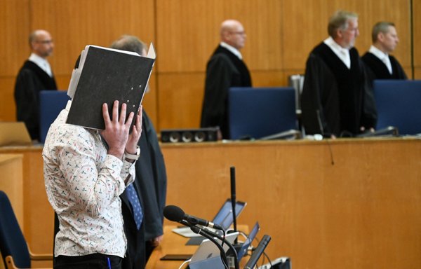 Iraqi ISIS element Taha al-Jumailly hides his face as judges arrive in the courtroom for the start of his trial for genocide and murdering a young Yazidi girl he held as a slave, on April 24, 2020, at the Higher Regional Court in Frankfurt, Germany. [Arne Dedert/Pool/AFP]