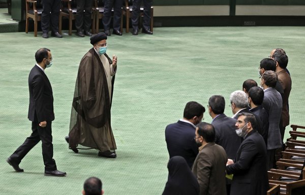 Iranian President Ebrahim Raisi leaves the podium after delivering a speech during a parliament session in Tehran on December 1. [Atta Kenare/AFP]