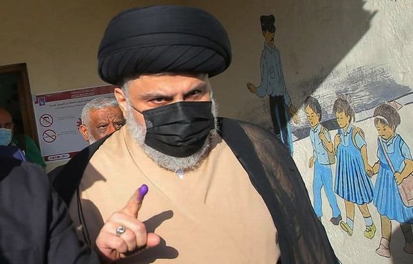 Muqtada al-Sadr displays his inked finger after casting his vote in the legislative elections on October 10. [Muqtada al-Sadr's office]