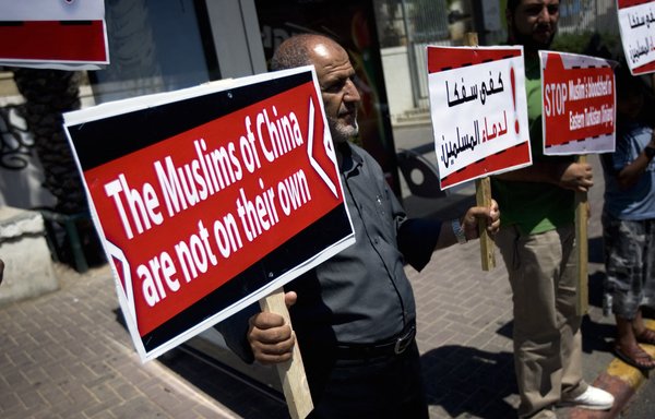 Arab men protesting China's oppression of Muslims in Xinjiang. [David Furst/AFP]