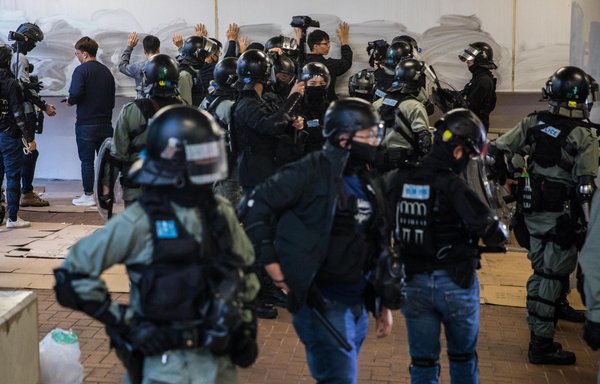 Police detain people after a rally in Hong Kong in 2019 to show support for oppressed Muslims in Xinjiang. [Dale de la Rey/AFP]