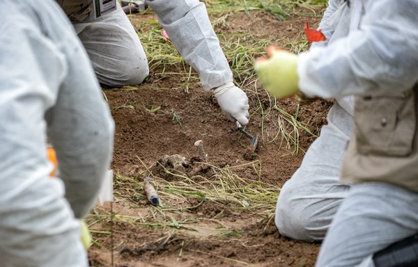Forensic workers inspect a zone during the exhumation of a mass-grave of hundreds of Yazidis killed by ISIS in the northern Iraqi village of Kojo in Sinjar district on March 15, 2019. [Zaid al-Obeidi/AFP]