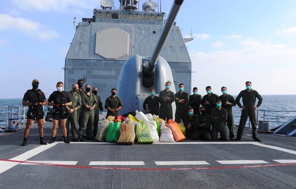 Sailors stationed aboard the guided-missile cruiser USS Port Royal, operating in support of the Combined Maritime Forces (CMF), monitor bags of suspected narcotics seized from a stateless dhow in the international waters of the North Arabian Sea December 18, 2020. [US Navy]