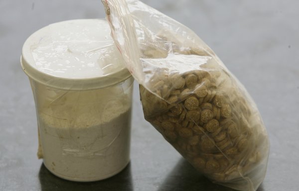 Captagon pills are displayed along with a cup of cocaine at an office of the Lebanese Internal Security Forces Anti-Narcotics Division in Beirut on June 11, 2010. [Joseph Eid/AFP]