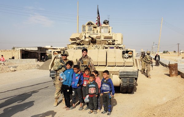 US forces from the international coalition pose with children during a patrol led by the Syrian Democratic Forces. [Combined Joint Task Force - Operation Inherent Resolve]