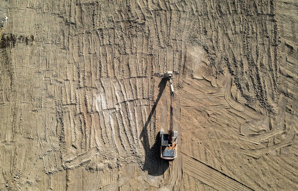 An excavator ploughing a field to search for land mines and unexploded ordnance near the village of Hassan-Jalad, north of Mosul, on November 29. [Zaid al-Obeidi/AFP]