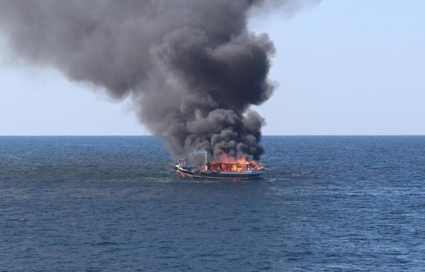A fire burns aboard a fishing vessel that was found to be transporting illegal drugs in the Gulf of Oman on December 15. The US Navy rescued five Iranians from the vessel. [US Navy]