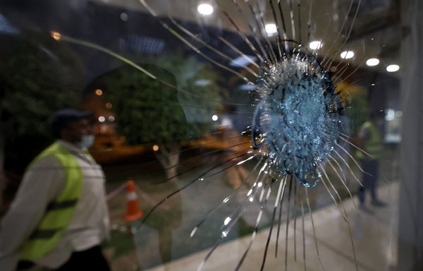 Saudi airport personnel are pictured behind shrapnel-riddled glass at Saudi Arabia's Abha airport on August 31, after a drone attack wounded eight people. [Fayez Nureldine/AFP]