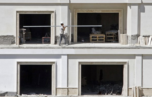 An Iranian builder works in a multi-storey building in Tehran's wealthy northern neighbourhood. [Behrouz Mehri/AFP]