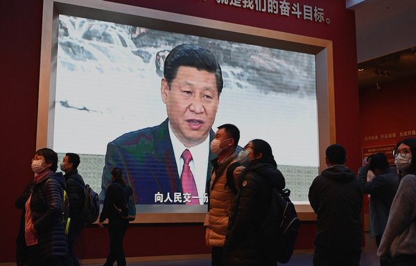Visitors walk in front of a screen showing Chinese President Xi Jinping at the Museum of the Communist Party of China in Beijing on November 11. [Noel Celis/AFP]
