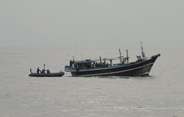 US service members from coastal patrol ship USS Tempest and USS Typhoon approach a stateless dhow vessel carrying illicit drugs while transiting international waters in the Arabian Sea on December 27. [US Navy]