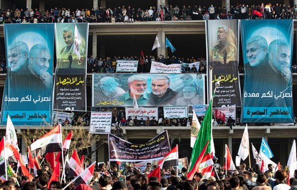 A crowd gathers during commemorations marking the second anniversary of the killing of top Iranian general Qassem Soleimani and his Iraqi lieutenant Abu Mahdi al-Muhandis (posters), in the southern Iraqi city of Basra, on January 8. [Hussein Faleh/AFP]