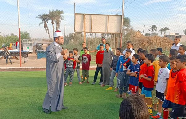 An Al-Azhar preacher talks to a group of children at a youth club. [Al-Azhar Islamic Research Academy]