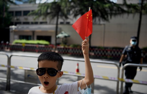 A boy waves a Chinese flag in front of the US consulate in Chengdu, China, July 26, 2020. [Noel Celis/AFP]