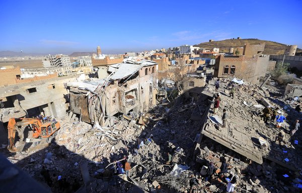 Yemenis inspect the damage following overnight retaliatory air strikes by the Arab coalition targeting Houthi-held Sanaa, on January 18. The Houthis staged a deadly attack a day earlier against Arab coalition ally Abu Dhabi. [Mohammed Huwais/AFP]