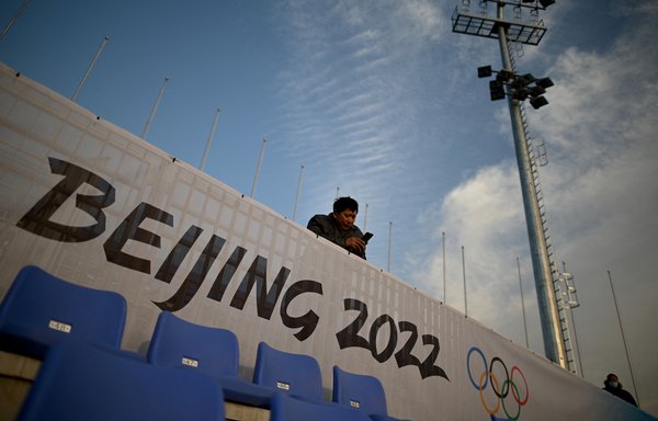 A man uses his mobile phone at the spectator area of an Olympic venue in Beijing on December 15. [Noel Celis/AFP]