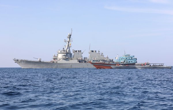 The guided-missile destroyer USS Cole transfers control of a stateless fishing vessel to Yemen's coast guard on January 21. [US Navy]