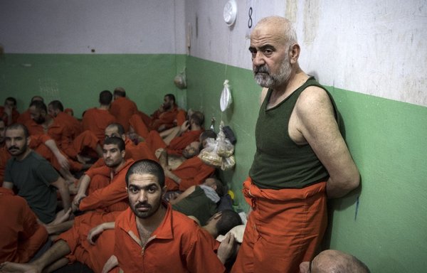 This file photo taken October 26, 2019, shows men suspected of being affiliated with ISIS gathered in a cell of the Sinaa prison in the Ghwayran neighbourhood of the northeastern Syrian city of al-Hasakeh. [Fadel Senna/AFP]