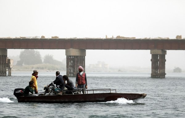 Syrians cross the Euphrates River from al-Raqa to the rural villages south of the city on ferries on October 15, 2018. [Delil Souleiman/AFP]