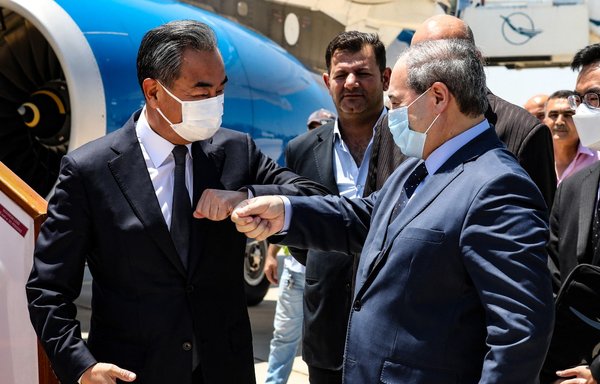 Syrian Foreign Minister Faisal Mekdad receives his Chinese counterpart Wang Yi at the airport in Damascus on July 17. [Louai Beshara/AFP]