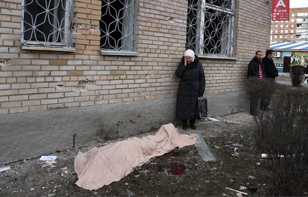 A woman cries near the body of her son, killed during a shelling in Tekstilshik district, Donetsk region, Ukraine, on February 4, 2015. The Kremlin is plotting to 'produce a very graphic propaganda video, which would include corpses and actors that would be depicting mourners and images of destroyed locations,' the US military said. [Dominique Faget/AFP]