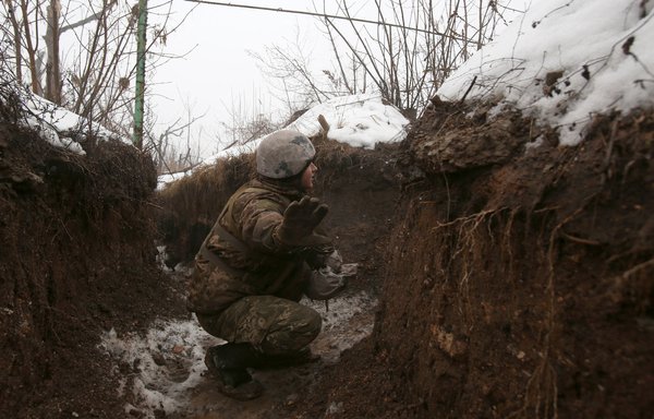 A Ukrainian serviceman gestures in a trench on the frontline with the Russia-backed separatists near Avdiivka, Donetsk region, on February 3. [Anatolii Stepanov/AFP]