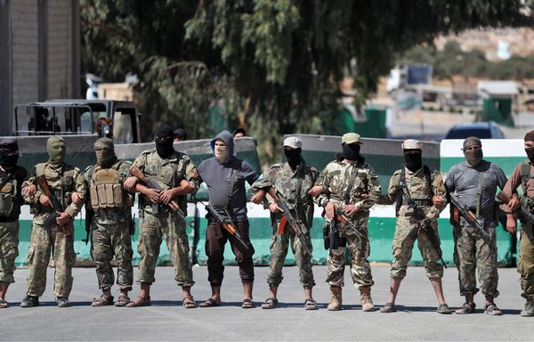 Tahrir al-Sham elements block demonstrators from approaching the Bab al-Hawa crossing between Syria's Idlib province and Turkey during a protest on September 20, 2019. [Omar Haj Kadour/AFP]