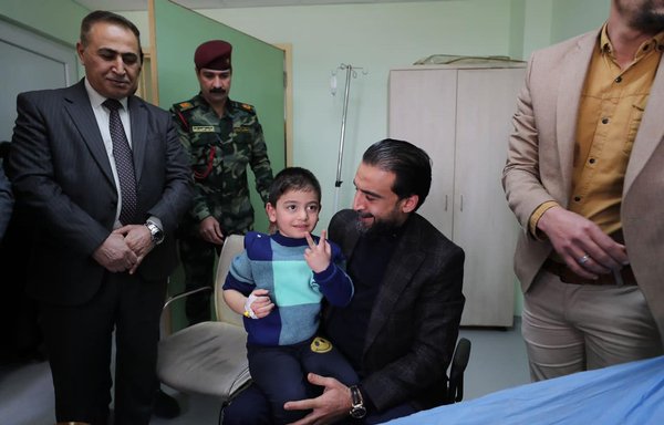 Iraqi Parliament Speaker Mohammed al-Halbousi checks on a child injured by rockets that fell January 25 near his house. [Mohammed al-Halbousi/Facebook]