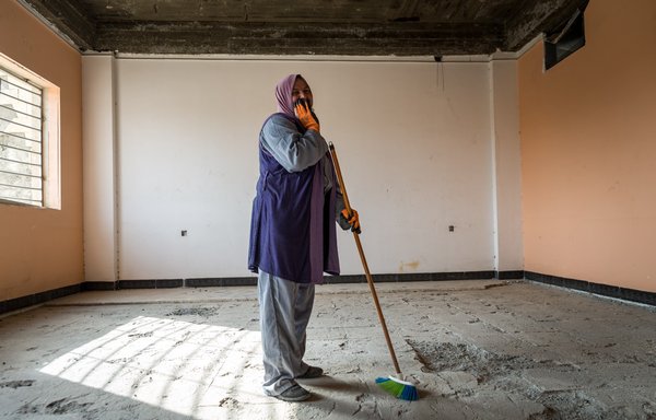 یک زن عراقی در ۱۷ اسفند ۱۳۹۶، مدرسه ای را که در جریان نبردهای بیرون راندن داعش آسیب دیده بود، تمیز می کند. [برنامه توسعه سازمان ملل متحد]