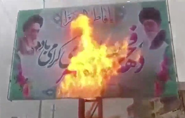 A video screenshot of a billboard featuring Islamic Republic founder Rouhollah Khomeini and Supreme Leader Ali Khamenei being set alight. [File]