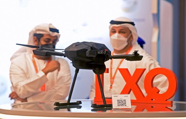 Visitors stand by a mock-up of an QX-1 loitering munitions 'kamikaze drone' by the EDGE advanced technology group for defence on display at the UMEX Exhibition showcasing drones, robotics and unmanned systems at the Abu Dhabi National Exhibition Centre on February 22. [AFP]