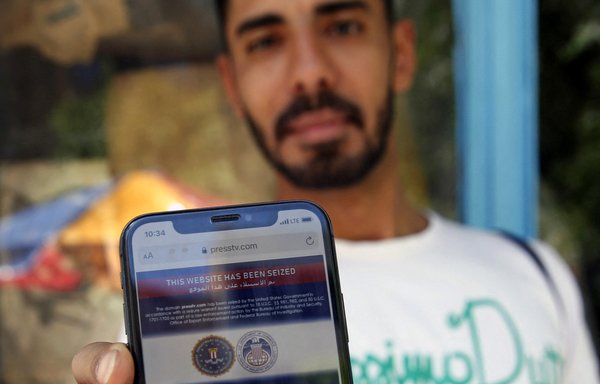 An Iranian man shows on his mobile phone a statement declaring the website of Iran's English-language television station Press TV 'has been seized by the US Government', in Tehran on June 23. [AFP]