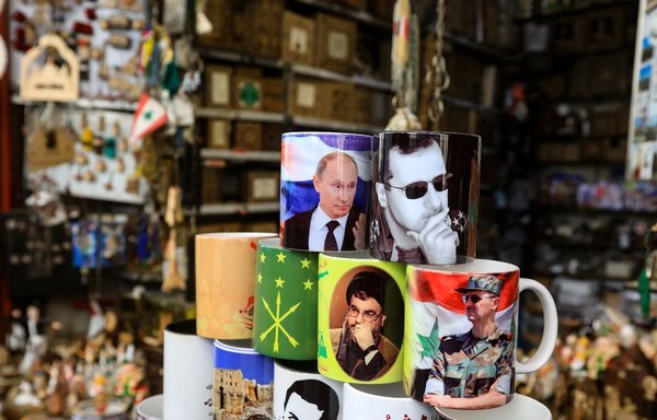أشياء تحمل صور الرئيس السوري بشار الأسد والرئيس الروسي فلاديمير بوتين وزعيم حزب الله حسن نصرالله معروضة في متجر هدايا تذكارية في الحي القديم بالعاصمة السورية دمشق، يوم 27 شباط/فبراير. [لؤي بشارة/وكالة الصحافة الفرنسية]