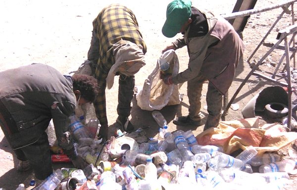 يمنيون يجمعون قوارير المياه الفارغة كمصدر رزق. [هيثم محمد/المشارق]