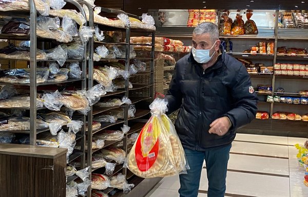 رجل يحمل أكياسا من الخبز في أحد الأفران بلبنان الذي يشهد نقصا في القمح نتيجة غزو روسيا لأوكرانيا. [نهاد طوباليان/المشارق]