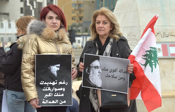 متظاهرون يحتشدون أمام تمثال المغترب قرب مرفأ بيروت في 4 آذار/مارس، حاملين لافتات تحمّل حزب الله مسؤولية الأزمة الراهنة التي بمر بها لبنان. [زياد حاتم/المشارق]