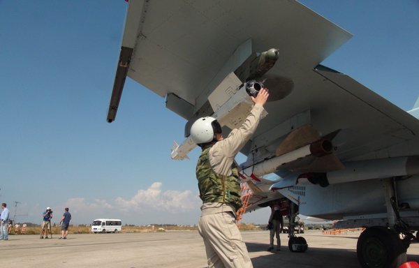 A picture taken on October 5, 2015, shows Russian air force pilots and technicians checking a Russian Su-30 fighter jet at the Hmeimim air base in the Syrian province of Latakia. [Komsomolskaya Pravda/AFP]