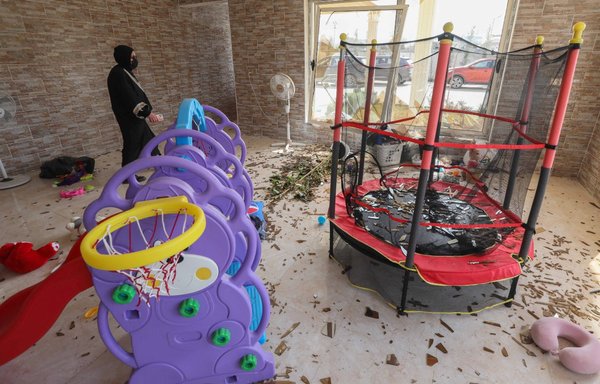 A woman inspects the damage in the children's room at a house in Erbil following an overnight attack on March 13 claimed by the IRGC, in which a dozen ballistic missiles targeted the city. [Safin Hamed/AFP]