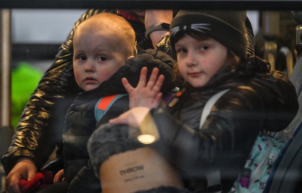 Children sit on a bus after crossing the Ukrainian-Polish border at Medyka March 14. There are increasing concerns that Russia will use chemical weapons in its war on Ukraine. [Louisa Gouliamaki/AFP]