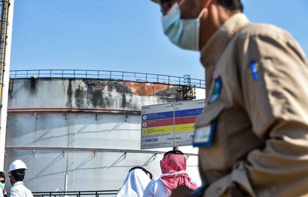 Men look at a damaged silo following an attack on the Saudi Aramco oil facility in Saudi Arabia's Red Sea city of Jeddah on November 24, 2020. [Fayez Nureldine/AFP]
