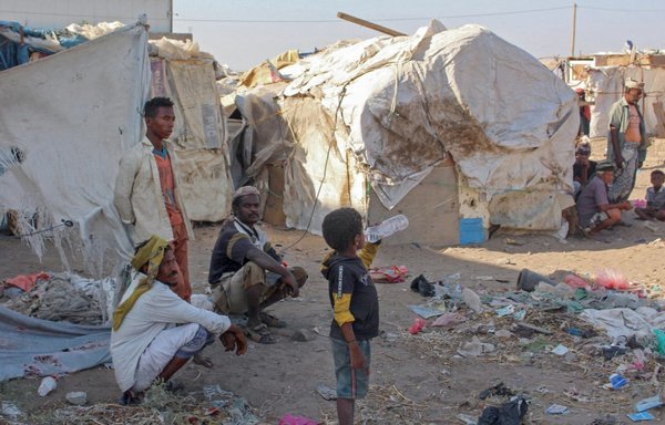 Internally displaced people sit by their tents at a camp north of Yemen's southern city of Aden, on March 6. [Saleh al-Obeidi/AFP]