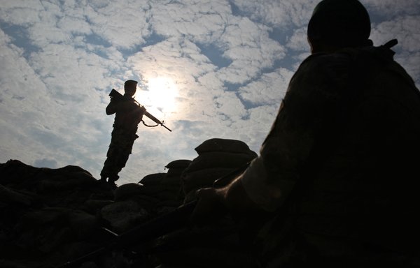 Iraqi soldiers stand guard near the Iraqi city of al-Qaim at the Iraqi-Syrian border on November 11, 2018. Iraqi troops reinforced their positions along the porous frontier with Syria, fearing a spillover from clashes there between ISIS and US-backed forces. [Ahmad al-Rubaye/AFP]