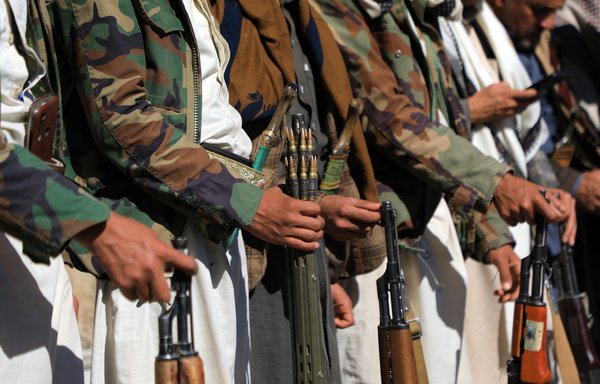 Carrying weapons, members of the Iran-backed Houthis attend a rally in Sanaa on January 27. [Mohammed Huwais/AFP]
