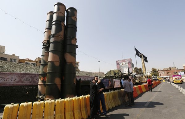 People walk past a Russian-made S-300 air defence system displayed on Baharestan square in Tehran on September 25, 2017. [Atta Kenare/AFP]