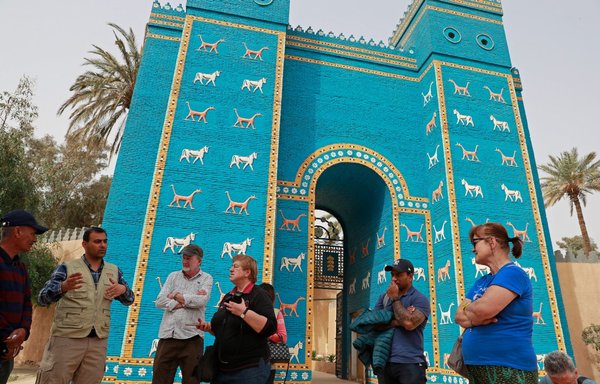 Foreign tourists visit the Ishtar Gate, the eighth gate to the ancient city of Babylon, some 100km south of Baghdad, on March 7. [Ahmad a-Rubaye/AFP]