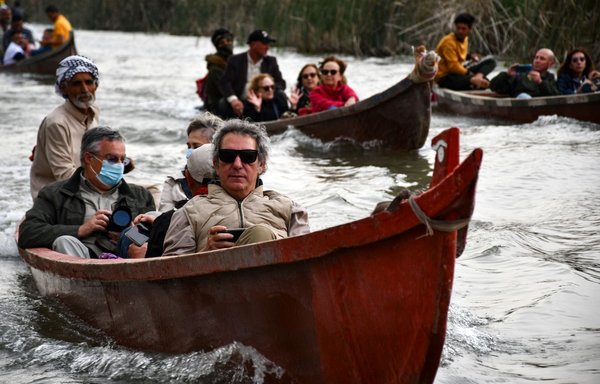 سائحون إسبان من أهوار الجبايش في جنوبي العراق يركبون قوارب أثناء تجولهم في المنطقة يوم 25 شباط/فبراير. [أسعد نيازي/وكالة الصحافة الفرنسية]